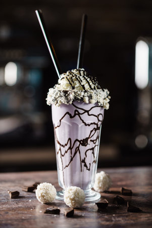 A luxurious purple milkshake topped with whipped cream and chocolate drizzle delights the senses.の写真素材