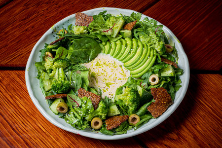 A beautifully arranged salad showcases greens, avocado, and unique toppings, inviting enjoyment.
