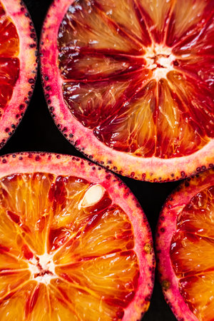 Sliced blood oranges showcase their vibrant colors and juicy interiors beautifully.の写真素材