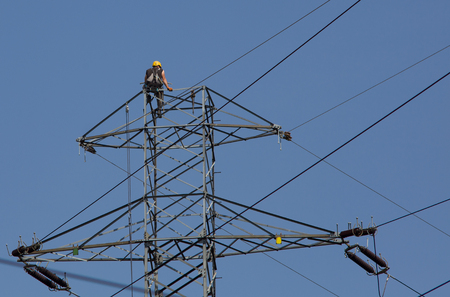 Electrician climb high, work on electric pole. Electrician repair system of electric wire.の写真素材
