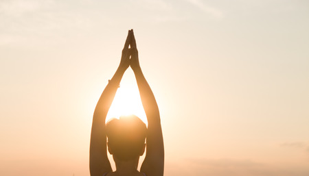 Young athletic woman practicing yoga. Meditation and yoga practicing at sunset.の写真素材