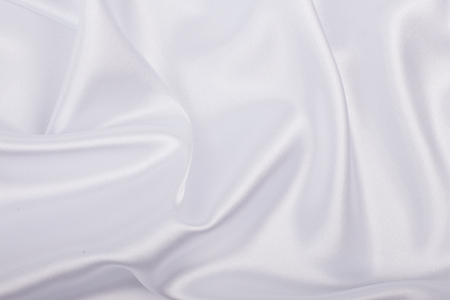 White satin fabric as background. Abstract luxury cloth or liquid wave.の写真素材
