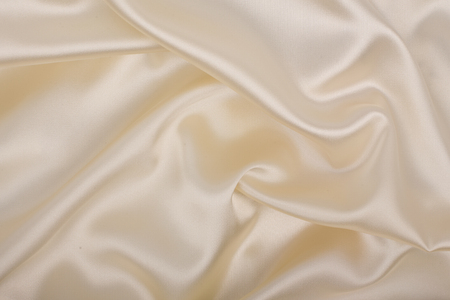 Soft  ecru satin, light background. Abstract luxury cloth or liquid wave.の写真素材