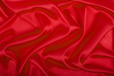 Red satin fabric, luxury background. Artistic fabric texture, abstract.の写真素材