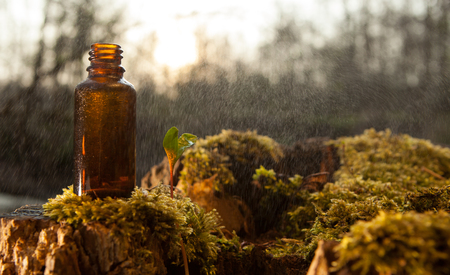 Natural moisturizing, oil. Unconventional medicine. A pharmacy bottle in a stream of water.の写真素材