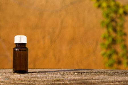 A bottle of essential oil with herbs, fresh flowers.