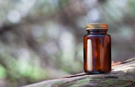 Herbal Drug Capsules In Brown Glass Bottle On Natural Background. Copy Spaceのeditorial素材