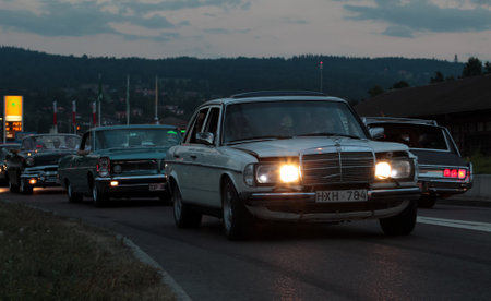 Rattvik, Sweden - July 27.2013: Classic Car Week Rttvik - White Mercedes-Benz W123, lights on at night.のeditorial素材