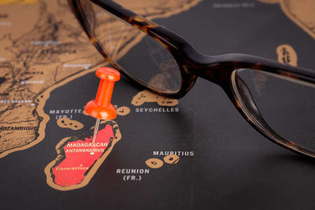 Location Madagascar. Red pins and glasses on the map. Close-up, the concept of travel.の写真素材