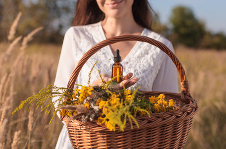 A woman collecting herbs, essential oil, bottle. Herbal medicine - concept.の写真素材