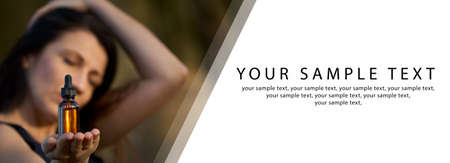 Female holding a bottle holding a bottle with drops of oil. Website banner, concepts of alternative medicine. Copy space.の写真素材
