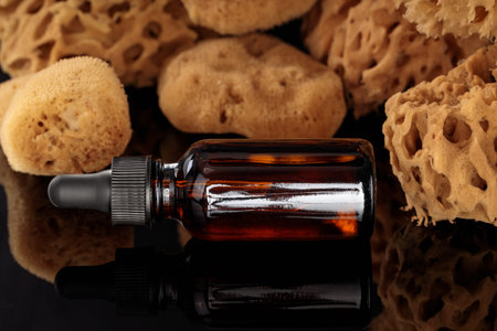 Spa and beauty care set with bottle of cosmetic oil sea. Natural sponges in background