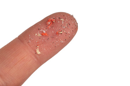 Micro plastic. Small plastic pellets on the finger. Close-up of microplastics lay. Isolated
