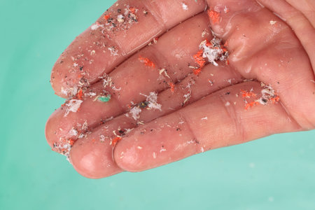 Hand details showing microplastics over water Concept of water pollution. Idea for climate change.