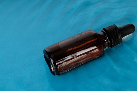 Brown bottle in stray water, mock-up. Cosmetic product.の写真素材