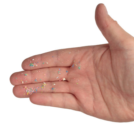 Microplastic on the hand, an exisolated background. The environmental problem with plastic