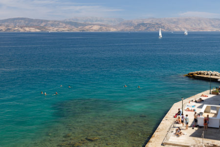 Bathing in Corfu town, blue water. In the background, a mountain range.の写真素材