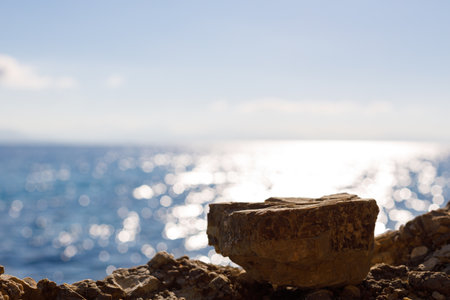 Blank space with beautiful blue sea background for montage products display. Stone against a background of beach, water.の写真素材