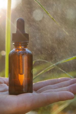 Dropper bottle held in your hand alternative herbal medicine supplement.の写真素材