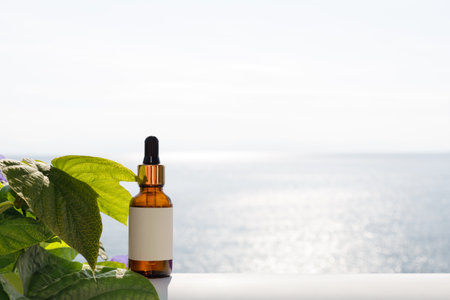 Dropper for cosmetic product with beautiful sea background, blank space for text.の写真素材