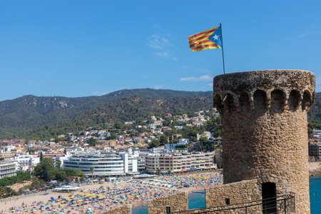Tossa De Mar, Spain - 12 August 2023 Tossa de Mar, the tower with Catalonia flag in histric old town of Costa Bravaの写真素材