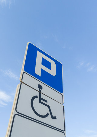 Handicapped Parking Signpost Against Blue Skyの写真素材