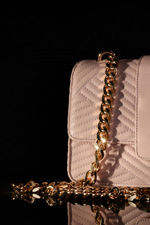 Elegant pink quilted purse with a gold chain strap, set against a black background.の写真素材