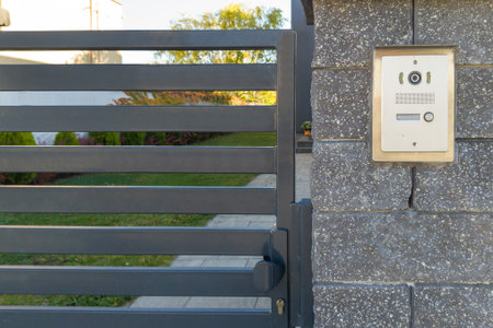 Metal Gate with Intercom on Stone Wall