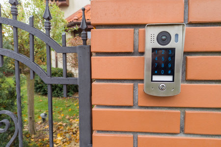 Gate intercom keypad on brick pillar