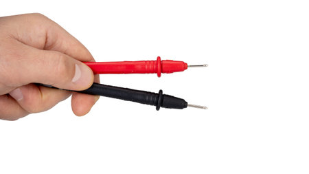 Hand Holding Red and Black Multimeter Probes Horizontally