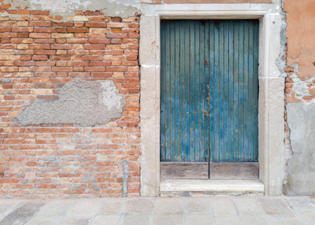 Old blue wooden door in brick wallの写真素材