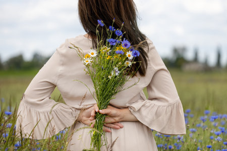 Woman Holding Wildflowers Behind Her Backの写真素材