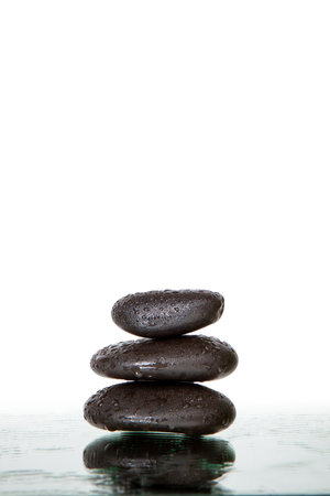 Stack of wet black spa stones isolatedの写真素材