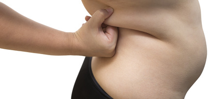 Woman squeeze belly fat wearing black underwear bra and pant on white isolatedの写真素材