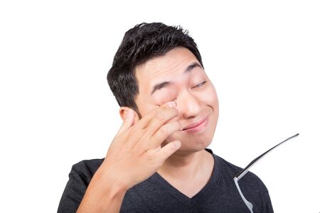 man rub eyes by finger remove dust in eyes isolated on white background wearing grey t-shirtの写真素材