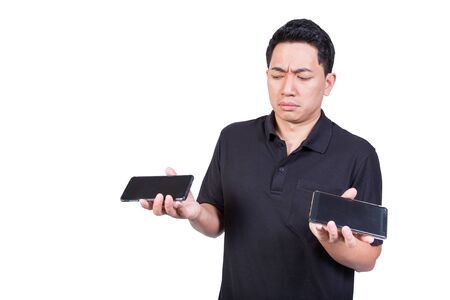 man holding two mobile phone in hand serious face trouble choice isolated on white backgroundの写真素材