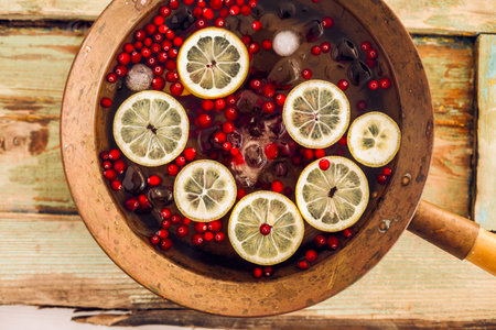 Cranberry lemon punch in a brass bowl on wooden tableの写真素材
