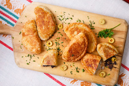Colombian empanadas (snack sized savory patties) on wooden board. Latin cuisine