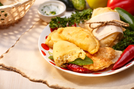 Cheese empanadas (savory patties) on wooden table. Selective focus, lit to resemble direct sunlightの写真素材