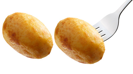 Whole baked fried potato, on a fork and alone. Clipping pathsの写真素材