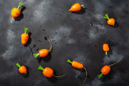 Short Rondo carrots on dark textured background with copy space, top view