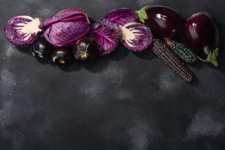 Dark anthocyanin-rich vegetables: eggplants, cabbage,maize,tomatoes atop dark background, top view, copy spaceの写真素材