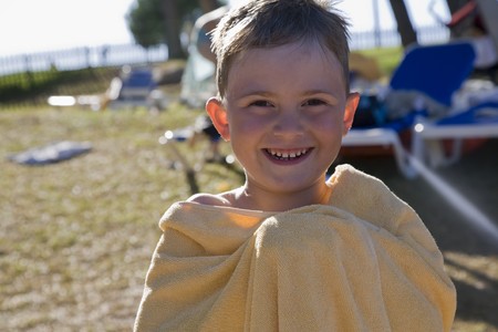 The smiling boy wrapped up in a towel.の写真素材