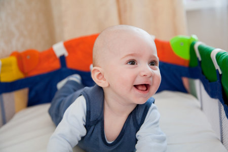 Cute baby plays in a baby cot