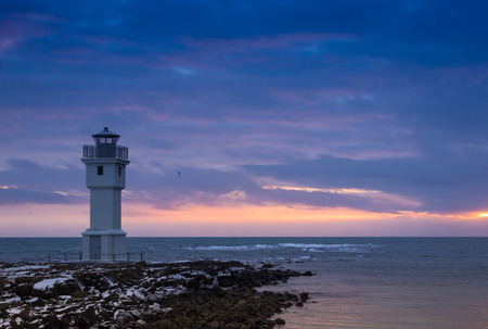 Landscape overlooking a beacon in sunset light against the ocean. Icelandの写真素材
