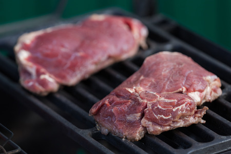 Two stakes are fried on the heated grill latticeの写真素材