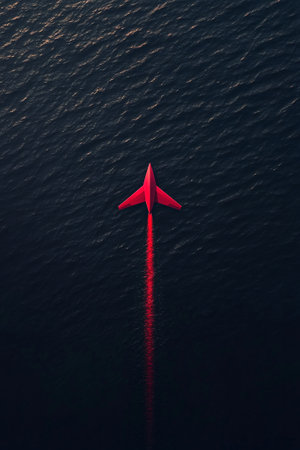 Red airplane flying over the oceanの素材