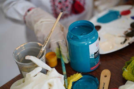 Palette with paints in the hands of artists. With rubber gloves and without but ready for work.の写真素材