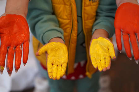 Drawing lessons at children's art school. Brushes, hands, paints. Children's palms in multi-colored paints.の写真素材