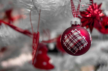 Beautiful Christmas red and silver balls on a white Christmas tree with decorations in the form of ribbons with the inscriptions Merry Christmas and Happy New Yearの写真素材